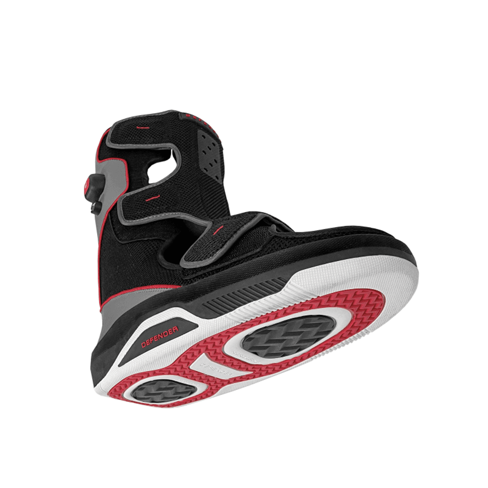The authentic Foot Defender protective medical boot shown at a dynamic angle, highlighting its gray and black paneling, red accents, and contoured offloading sole